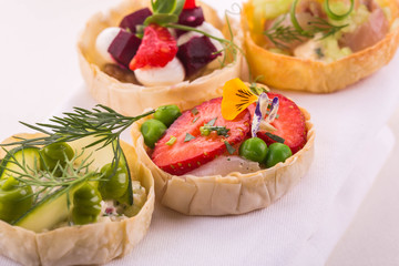 Tartlet with strawberry and a comb, a whitefish with egg and mayonnaise, goat cheese and baked beet, apple, a crab and shrimps