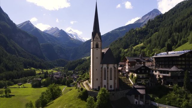 Wide aerial shot approaching tower in rural valley town / Heiligenblut, Austria