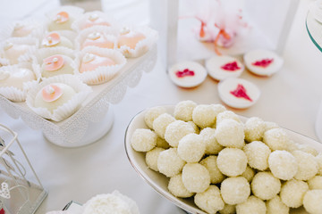 Obraz na płótnie Canvas Wedding reception dessert table with delicious decorated white cupcakes with frosting