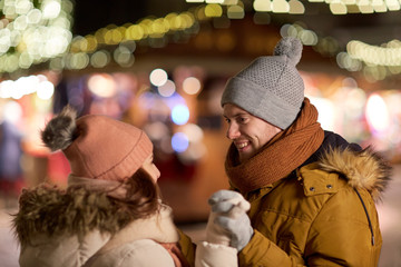happy couple holding hands at christmas market