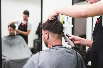 Professional barber doing a haircut to a male client.