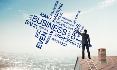 Young businessman standing on house roof and writing leadership 