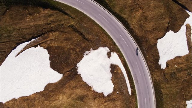 Wide aerial high angle shot of person riding bicycle on mountain pass / Grossglockner, Austria