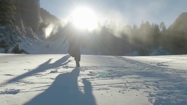 Running up the snowy ski slope toward sunset sun, trekking SLOW MOTION