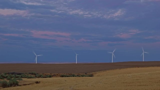 Windmills and farmland wheat fields harvested green energy renewable sunset 2