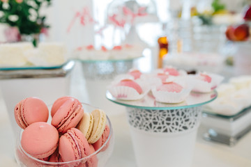 Wedding reception dessert table with delicious decorated white cupcakes with frosting