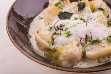 Pike and pike caviar pelmeni, is served with creamy sauce with champagne