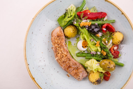 Tuna salad, is served with fresh vegetables and green olives, with quail eggs and fried potato