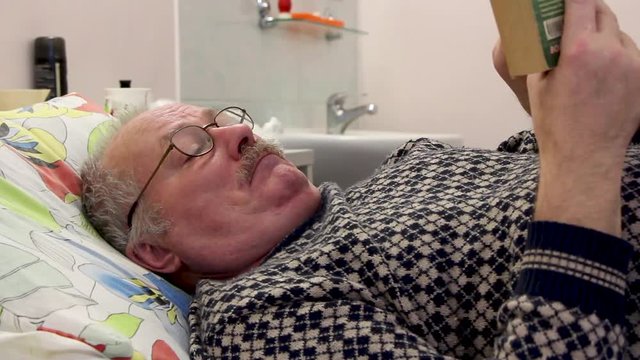 graybeard gaffer old man on hosp bed read