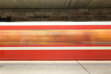 Moving red and white subway in the underground going past