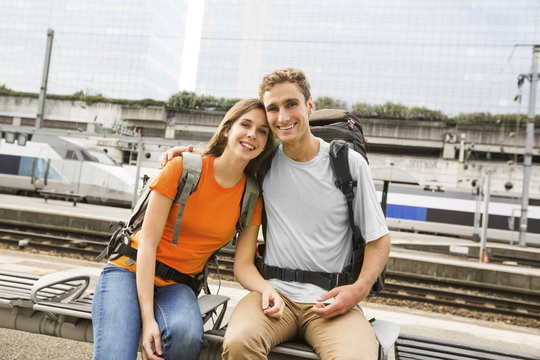 Caucasian couple waiting on bench at train station