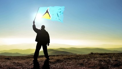 Successful silhouette man winner waving Saint Lucia flag on top of the mountain peak, Cinemagraph LOOP background - Powered by Adobe