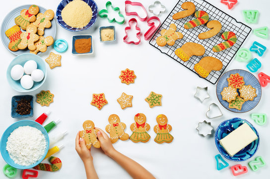 Gingerbread cookies with ingredients for baking and kids hands