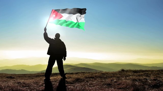 Successful silhouette man winner waving Jordan flag on top of the mountain peak, Cinemagraph LOOP background