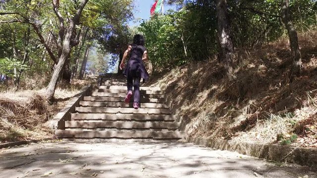 Following hiker sport woman in mountain forest walking over concrete stairs