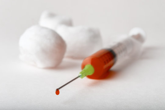 Macro view of drop of blood from syringe