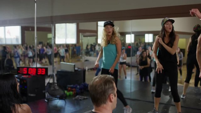 Medium panning shot of instructor leading exercise class / Orem, Utah, United States