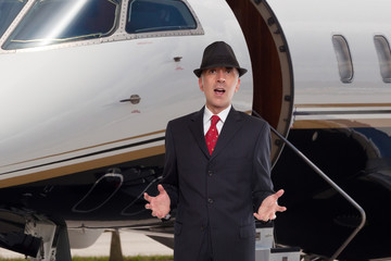 Business man in front of a corporate jet