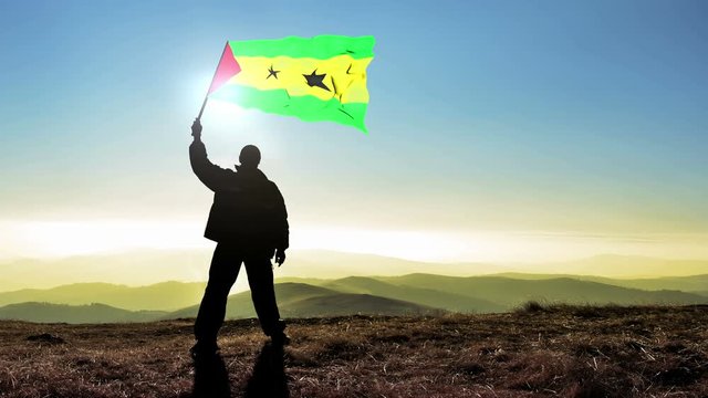 Successful silhouette man winner waving Sao Tome and Principe flag on top of the mountain peak, Cinemagraph LOOP background