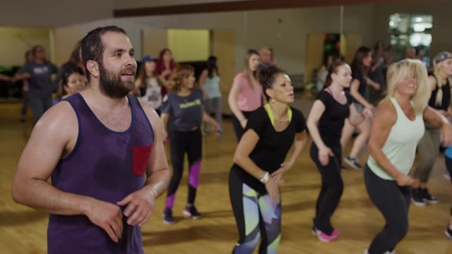Medium panning shot of people dancing in exercise class / Orem, Utah, United States