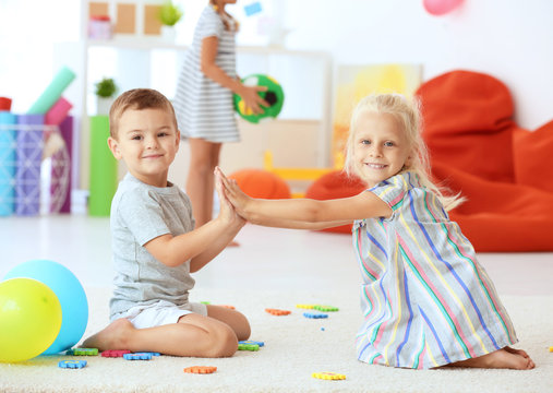Cute children playing a clapping game indoor