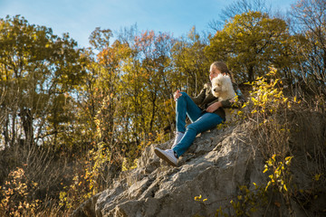 Girl and a dog  on the  rock