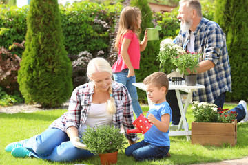 Elderly couple with grandchildren working in garden