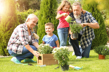 Elderly couple with grandchildren working in garden