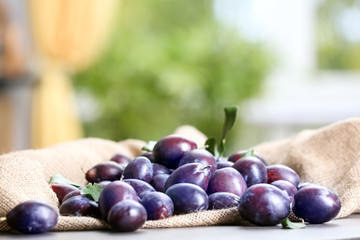 Fresh delicious plums on table