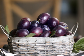 Fresh plums in wicker basket, closeup