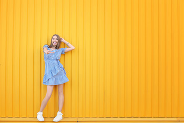 Obraz premium Attractive hipster girl posing near color wall