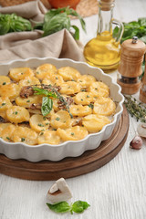 Baking dish with potato casserole on table