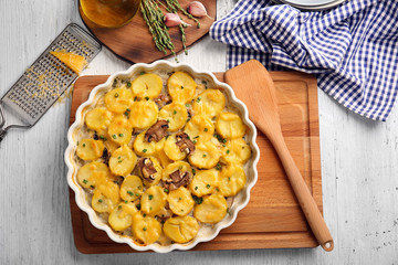 Baking dish with potato casserole on table