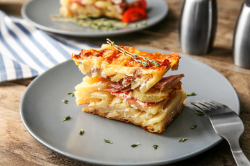 Plate with potato casserole on table