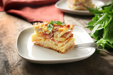 Plate with potato casserole on table