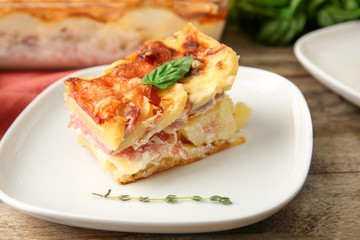 Plate with potato casserole on table