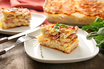 Plate with potato casserole on table