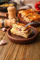 Plate with potato casserole on table