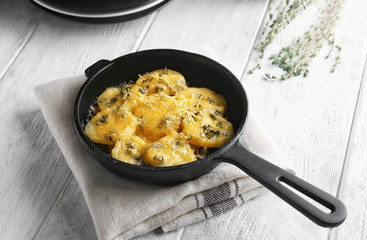 Frying pan with potato casserole on table