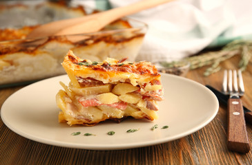 Plate with potato casserole on table