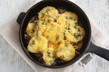 Frying pan with potato casserole on table