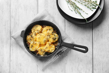 Frying pan with potato casserole on table