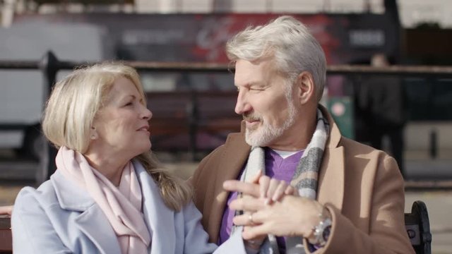 Portrait of happy mature couple sitting on a bench