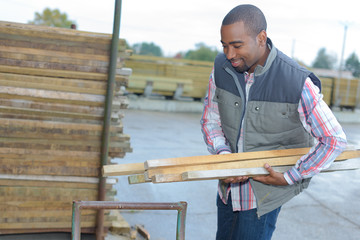 Man carrying wood in materials store