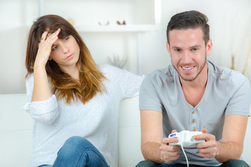 Obraz premium girl is bored by her boyfriend playing video game