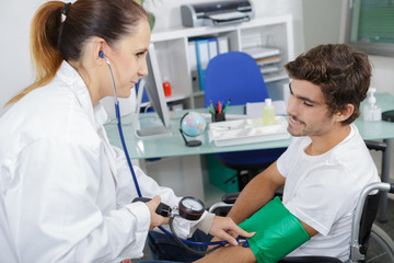 Naklejka na ściany i meble doctor measuring blood pressure of young man