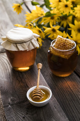 Honey and wooden stick are on a table