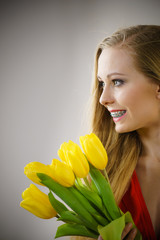 Pretty woman with yellow tulips bunch