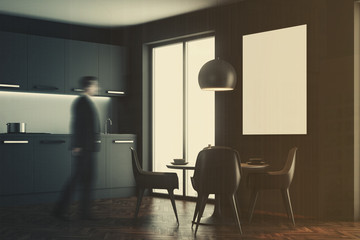 Man in a black dining room interior, side