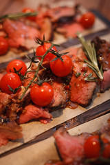 Roast beef with tomatoes and spices on the boards